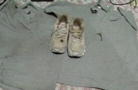 Camiseta e tênis queimados em cima de uma cama.